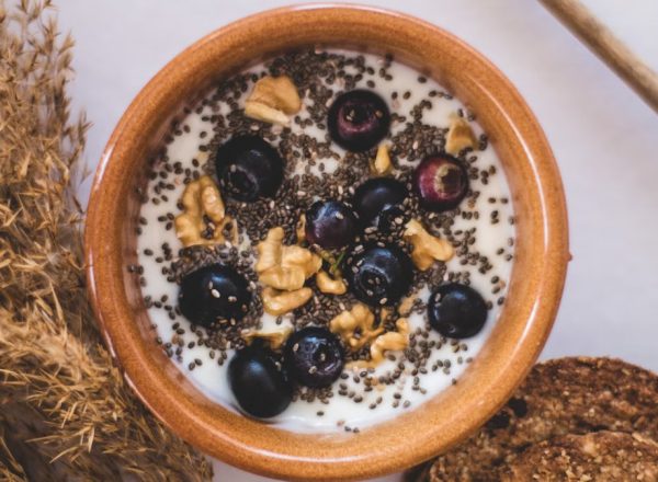 Top view of a nutritious bowl with yoghurt, blueberries, chia seeds, and walnuts.