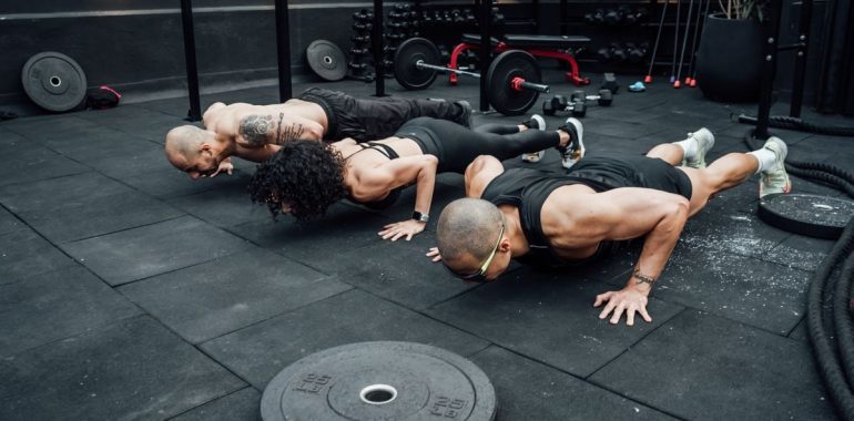 Fitness enthusiasts performing push-ups in a Mexico City gym. Emphasizing teamwork and strength.